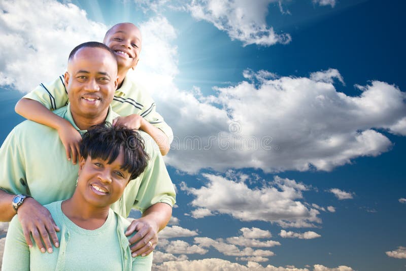 Happy African American Family Over Blue Sky, Sun Rays and Clouds. Happy African American Family Over Blue Sky, Sun Rays and Clouds.