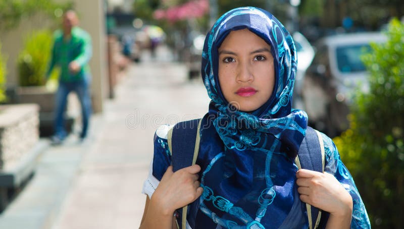 Синь красивой молодой мусульманской женщины нося покрасила hijab и рюкзак, представляя с заботливым серьезным выражением лица стоковые фото Синь красивой молодой мусульманской женщины нося покрасила hijab и рюкзак, представляя с заботливым серьезным выражением лица стоковые фото