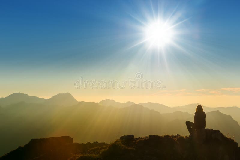 Lonely sad person sitting on mountain summit at dawn. Lonely sad person sitting on mountain summit at dawn