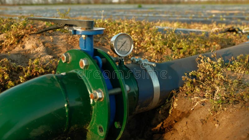 система ирригационных труб со счетчиком воды на большом поле