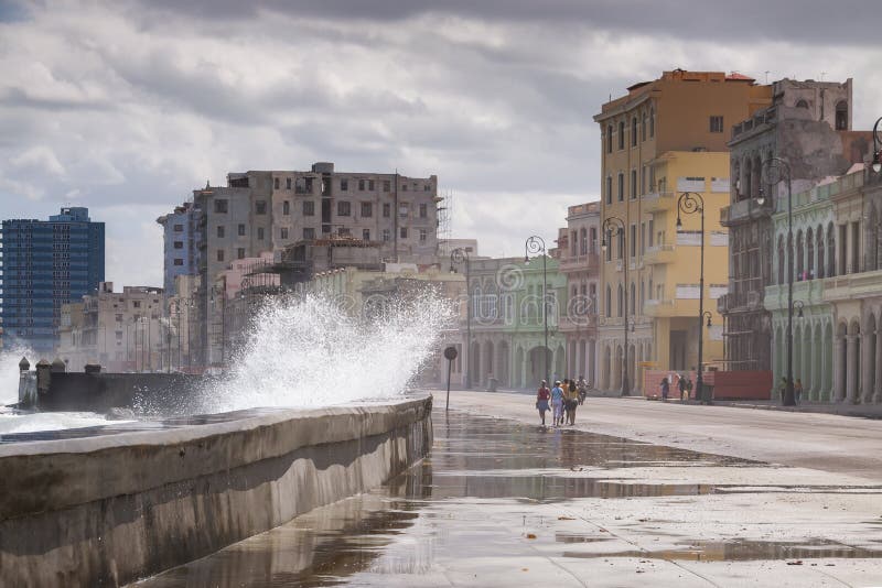 A strong wave jumps over the wall that protects the Malecon promenade, in the center of Havana, leaving the entire sidewalk wet and full of algae on a windy day. A strong wave jumps over the wall that protects the Malecon promenade, in the center of Havana, leaving the entire sidewalk wet and full of algae on a windy day