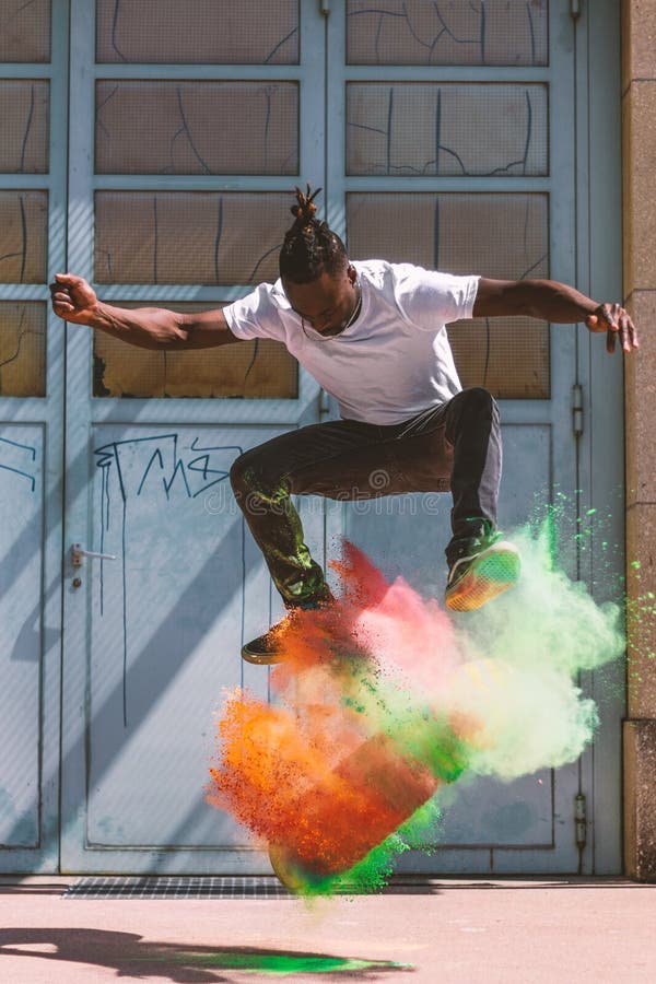 Скейтбордист делая kickflip с красочным порошком holi стоковые фото Скейтбордист делая kickflip с красочным порошком holi стоковые фото