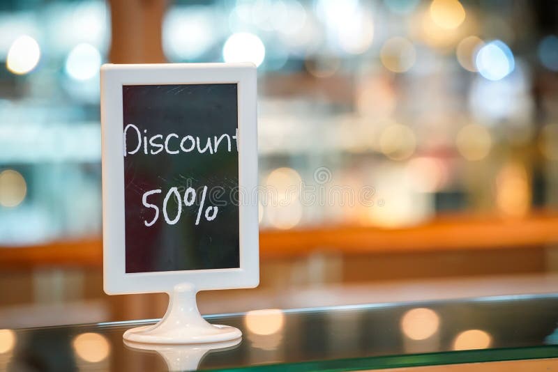 Скидка 50% на черной доске standy в магазине пекарни Красивая предпосылка расплывчатого и bokeh стоковые фото