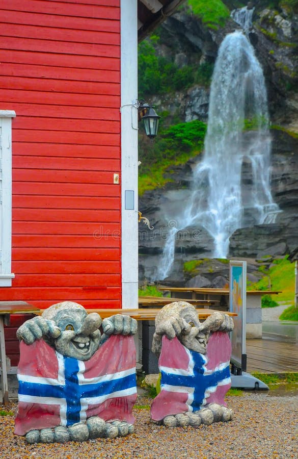 2 скульптуры троллей с норвежскими флагами и водопадом Steinsdalsfossen на заднем плане, Норвегия стоковое изображение 2 скульптуры троллей с норвежскими флагами и водопадом Steinsdalsfossen на заднем плане, Норвегия стоковое изображение