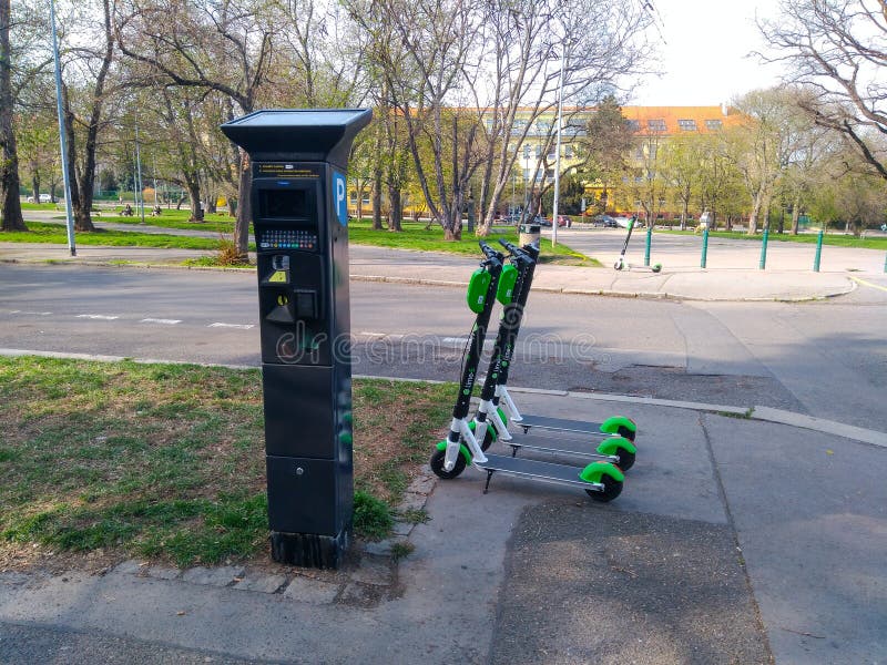 Скутеры Eletro стоят около паркуя машины стоковая фотография Скутеры Eletro стоят около паркуя машины стоковая фотография
