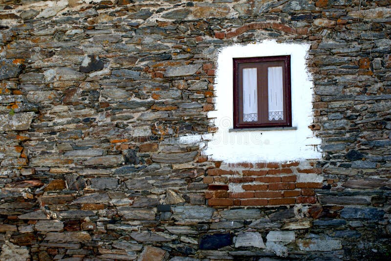 Славное окно с занавесами типичного каменного фасада Португалии