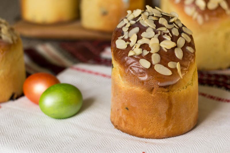 Сладкое kulich торта пасхи покрытое с хлопьями миндалины с покрашенными яйцами r стоковое изображение rf Сладкое kulich торта пасхи покрытое с хлопьями миндалины с покрашенными яйцами r стоковое изображение rf