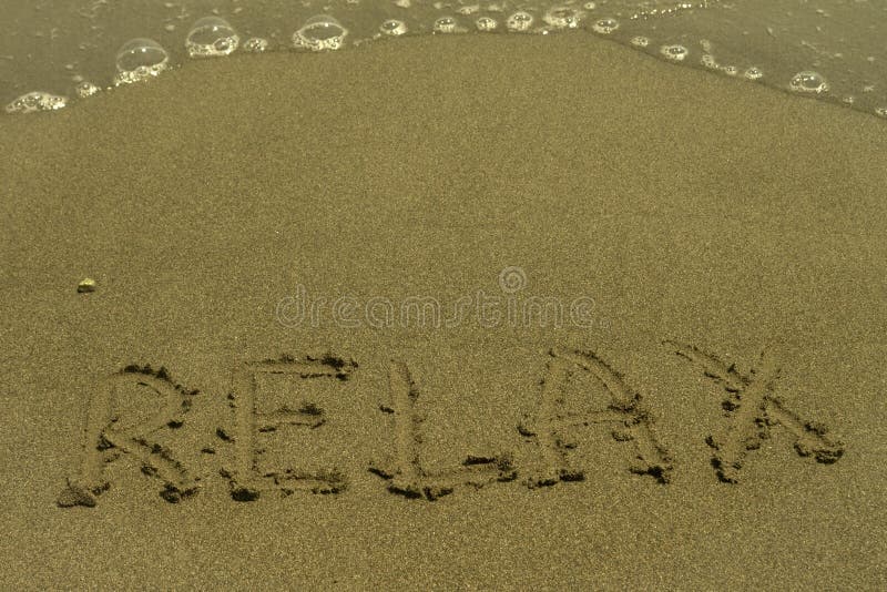 Слово Relax написанный на песчаном пляже стоковая фотография Слово Relax написанный на песчаном пляже стоковая фотография