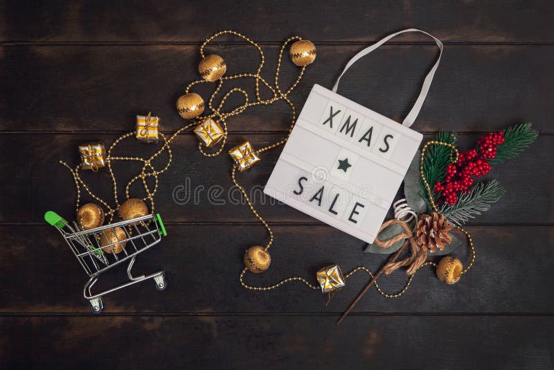 Слово продажи xmass на небольшой корзину с золотыми lightbox и подарки на деревянной фон стоковые изображения
