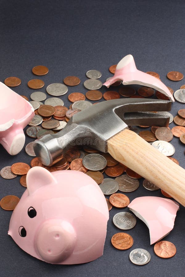 Financial savings concept image featuring a piggy bank broken by a hammer loaded with money. Top copy space available. Business & Finance Collection. Financial savings concept image featuring a piggy bank broken by a hammer loaded with money. Top copy space available. Business & Finance Collection.