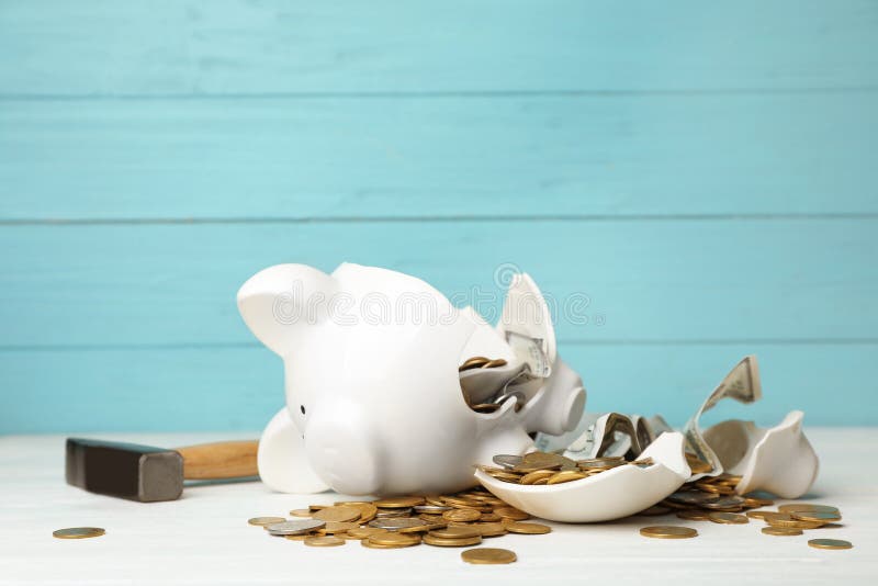 Broken piggy bank with money and hammer on table. Broken piggy bank with money and hammer on table
