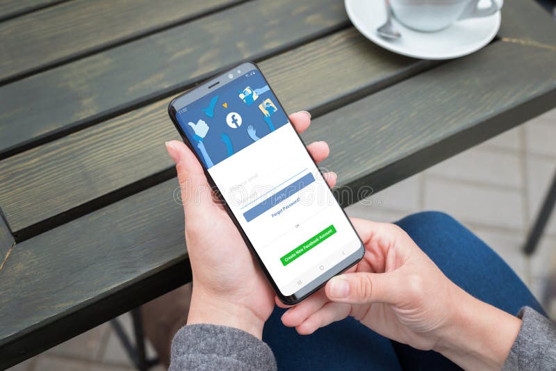 Смартфон галактики Samsung пользы женщины к имени пользователя на счете сети Facebook социальном стоковое изображение rf Смартфон галактики Samsung пользы женщины к имени пользователя на счете сети Facebook социальном стоковое изображение rf