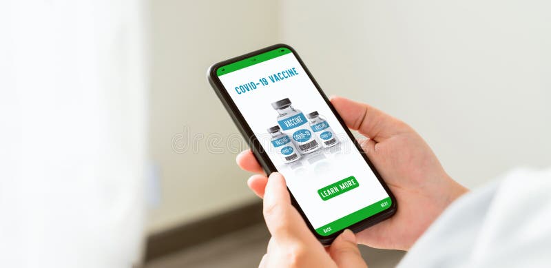 Смартфон холдинга руки и вакцина corona веб-страницы шоу в интернете с узнать больше кнопки. стоковое фото