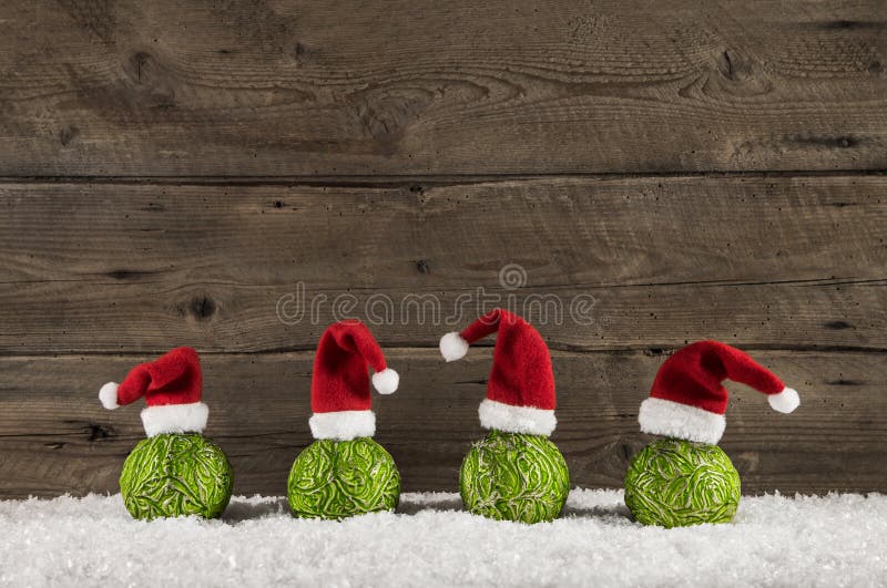 Смешная предпосылка рождества с зелеными шариками и шляпами santa на wo стоковое фото rf Смешная предпосылка рождества с зелеными шариками и шляпами santa на wo стоковое фото rf
