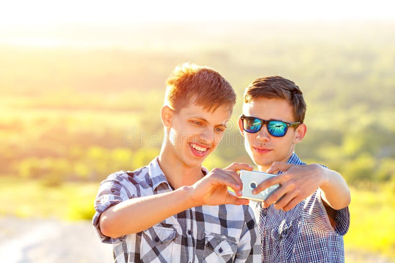 Смешные друзья принимают selfies на солнечный день стоковые фотографии rf Смешные друзья принимают selfies на солнечный день стоковые фотографии rf