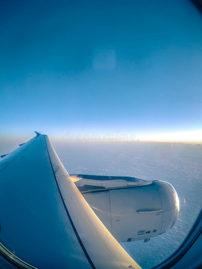 Смотреть вне окно самолета и летать над облаками стоковая фотография rf