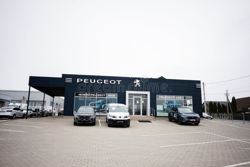 Современный автосалон Peugeot с различными моделями, припаркованными за пределами салона стоковые фото