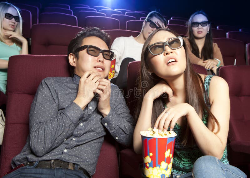 Couple sitting at the cinema, watching a horrors film. Cinema photo series. Couple sitting at the cinema, watching a horrors film. Cinema photo series