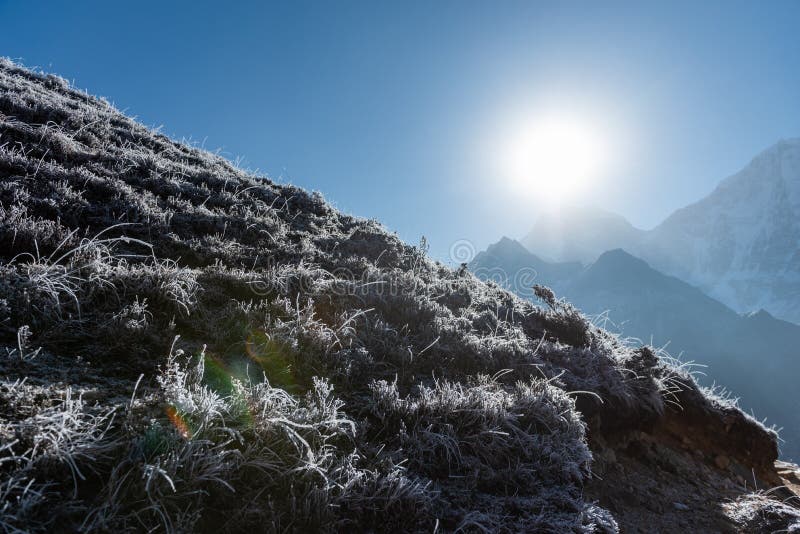 Sun hits the morning frost across the brown and dry hillside in Nepal on a clear day. Sun hits the morning frost across the brown and dry hillside in Nepal on a clear day.
