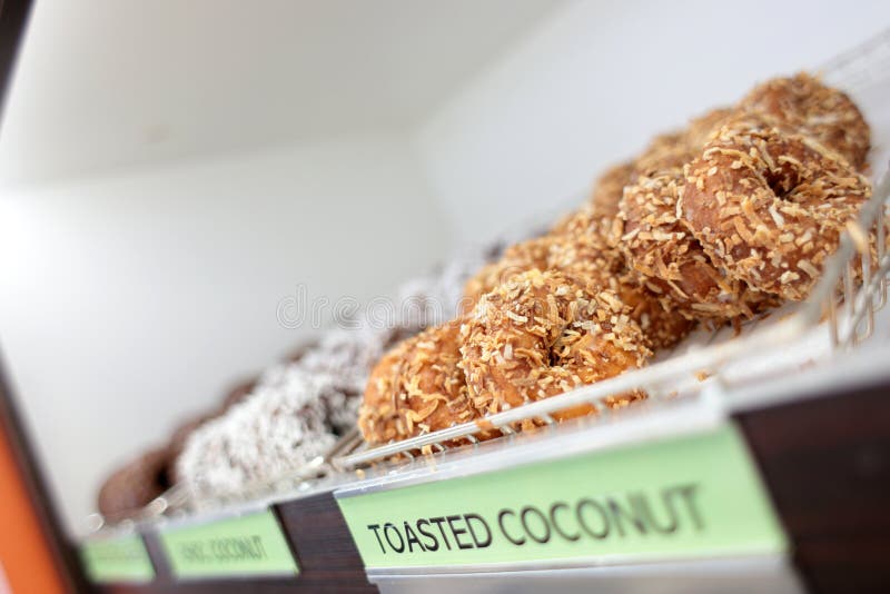 Сортировал свежие donuts на стеллажах для выставки товаров стоковая фотография Сортировал свежие donuts на стеллажах для выставки товаров стоковая фотография