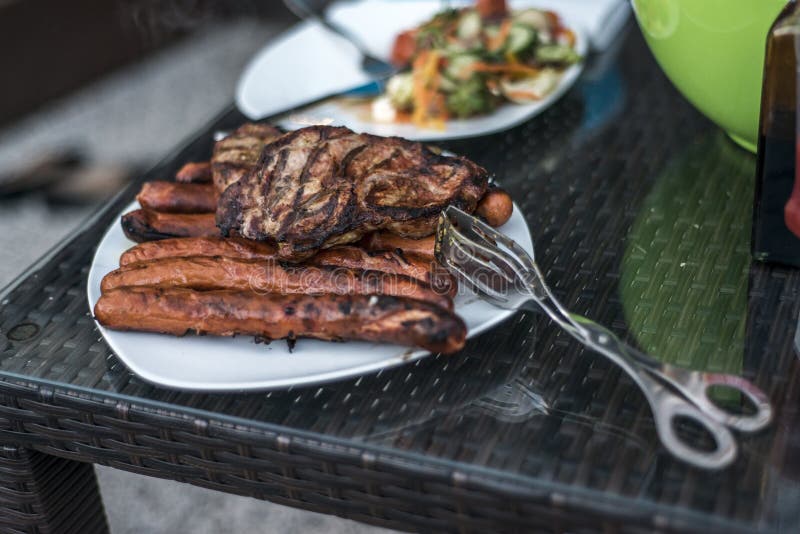 Сортированное очень вкусное зажаренное мясо с салатом в плите предпосылки белой на таблице для партии bbq семьи стоковые изображения rf Сортированное очень вкусное зажаренное мясо с салатом в плите предпосылки белой на таблице для партии bbq семьи стоковые изображения rf
