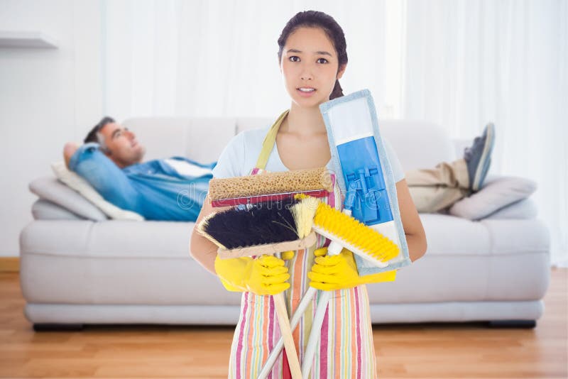 Составное изображение хмуриться удерживание женщины чистит щеткой и mops стоковые изображения rf Составное изображение хмуриться удерживание женщины чистит щеткой и mops стоковые изображения rf