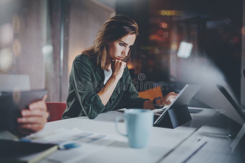 Сотрудники работая отростчатое фото Молодая женщина работая вместе с коллегами на просторной квартире офиса ночи современной Сыгр стоковые изображения Сотрудники работая отростчатое фото Молодая женщина работая вместе с коллегами на просторной квартире офиса ночи современной Сыгр стоковые изображения