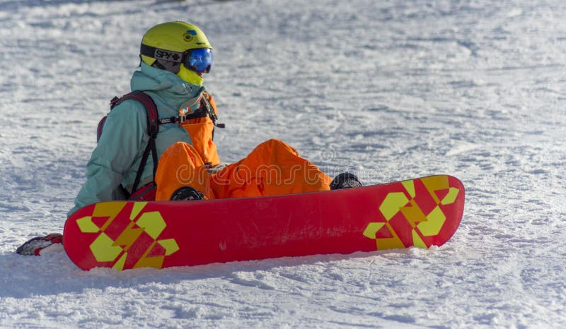 Сочи, Россия, 10-01-2018 Лыжный курорт Розы Khutor сидя snowboarder снежка стоковые изображения Сочи, Россия, 10-01-2018 Лыжный курорт Розы Khutor сидя snowboarder снежка стоковые изображения