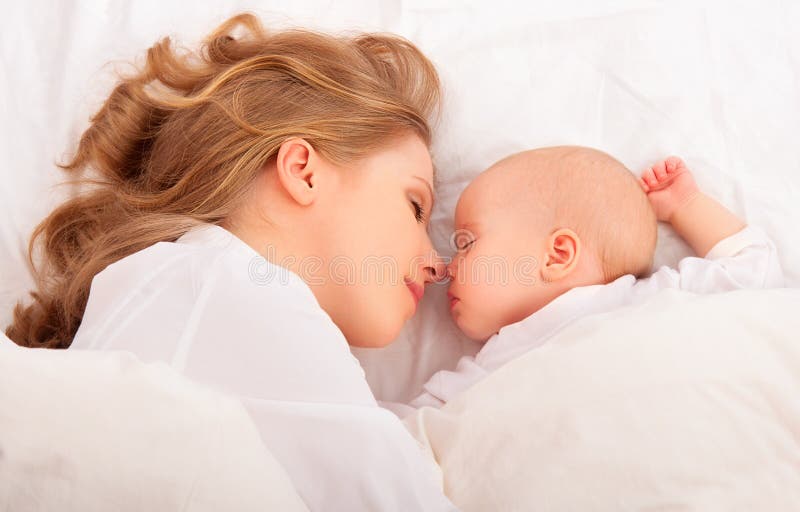 Спать совместно. мать обнимает newborn младенца в кровати стоковое изображение rf
