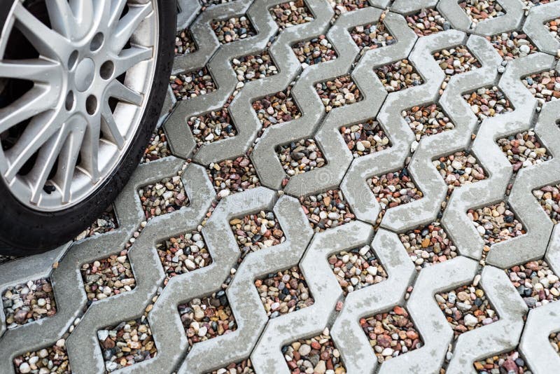 Сплавьте колесо автомобиля на влажной openwork конкретной мостоваой заполненной с красочными камешками стоковая фотография rf Сплавьте колесо автомобиля на влажной openwork конкретной мостоваой заполненной с красочными камешками стоковая фотография rf