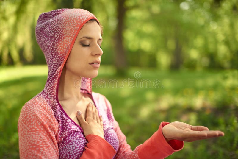 Спокойная и мирная женщина практикуя заботливый mindfulness осведомленности путем размышлять в природе на заходе солнца стоковая фотография rf