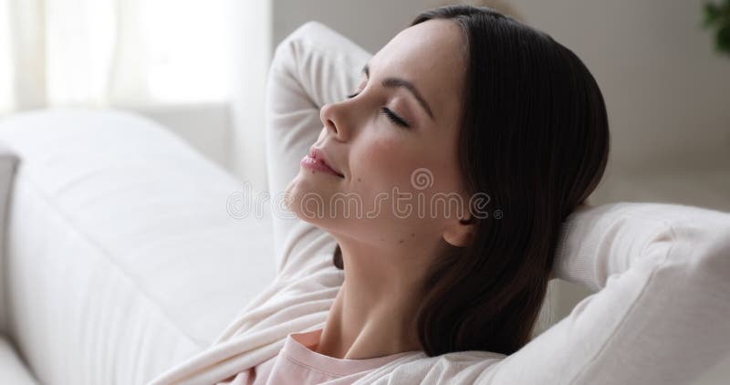 Спокойная расслабляющая молодая женщина в конце воздуха дивана дыхание вверх