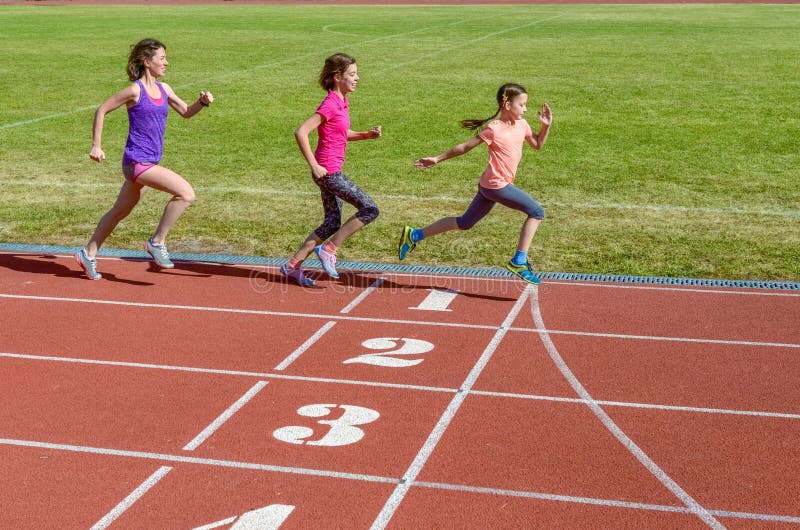 Family sport, mother and kids running on stadium track, training and children fitness concept. Family sport, mother and kids running on stadium track, training and children fitness concept