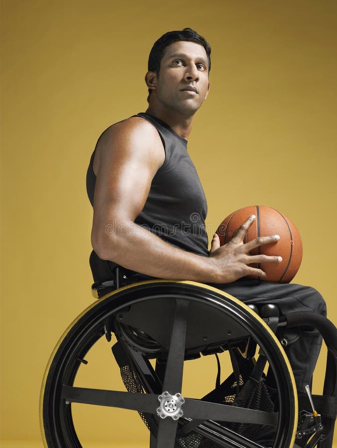 Спортсмен Paraplegic с баскетболом в кресло-коляске стоковая фотография Спортсмен Paraplegic с баскетболом в кресло-коляске стоковая фотография