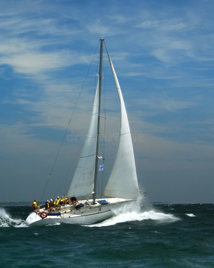 The large waves and strong wind are check on endurance. The white sparks of the sea rise up to a deck. White sails on a background the dark blue sky. The large waves and strong wind are check on endurance. The white sparks of the sea rise up to a deck. White sails on a background the dark blue sky.