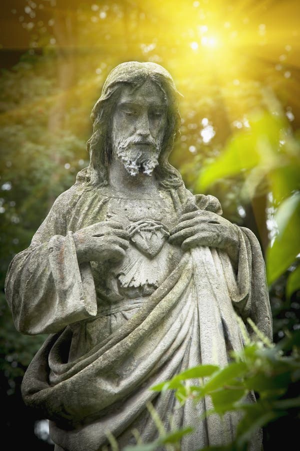 Старая каменная статуя Иисуса Христа в лучах света. Понятие бога, религии, убеждений