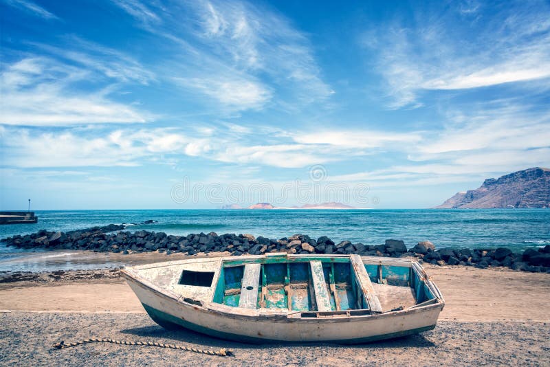 Старая красочная рыбацкая лодка, Атлантический океан на заднем плане, Лансароте, Канарские острова, Испания