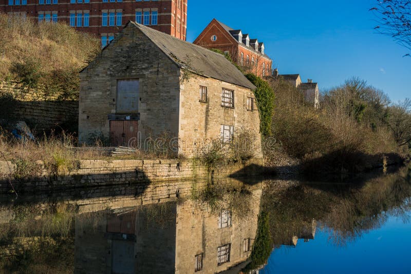 Старое здание отражая на воде в восстановленном канале Stroudwater в Stroud, Gloucestershire стоковая фотография rf Старое здание отражая на воде в восстановленном канале Stroudwater в Stroud, Gloucestershire стоковая фотография rf