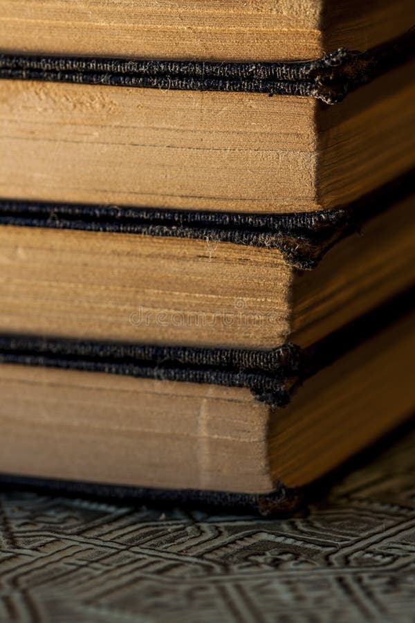 Старые несенные книги штабелированные на текстурированном поверхностном конце вверх стоковое фото Старые несенные книги штабелированные на текстурированном поверхностном конце вверх стоковое фото
