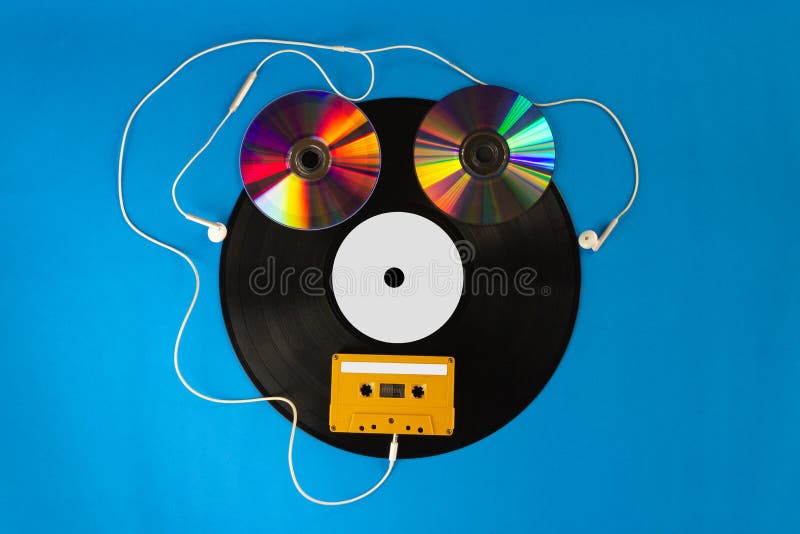 Старые показатели и CD винила с лентой магнитофонной кассеты создают форму робот и наушники уха на голубой предпосылке стоковая фотография Старые показатели и CD винила с лентой магнитофонной кассеты создают форму робот и наушники уха на голубой предпосылке стоковая фотография