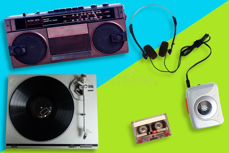 Old retro Vinyl record player or turntable, Portable tape player with radio and cassette tape and Headphone on a split yellow and blue background, gadgets for The 70-80-90`s. Old retro Vinyl record player or turntable, Portable tape player with radio and cassette tape and Headphone on a split yellow and blue background, gadgets for The 70-80-90`s