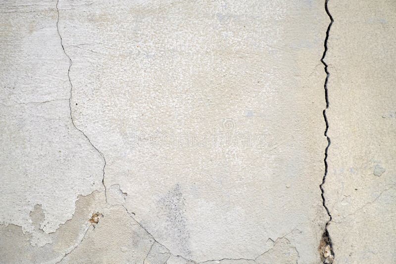 Old foundation and plaster wall with cracks. Building requiring repair closeup. Old foundation and plaster wall with cracks. Building requiring repair closeup