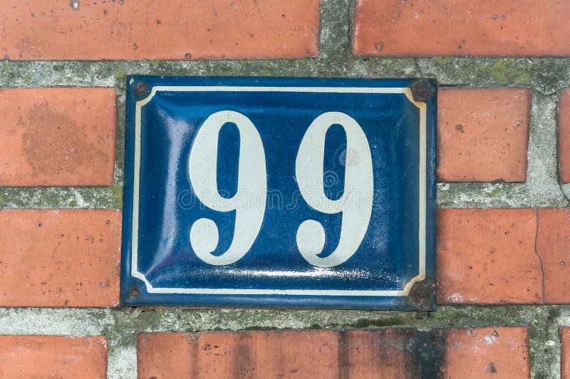 Старый винтажный медный штейн 99 99 адреса дома на фасаде кирпича стены жилого дома внешней на улице стоковое изображение rf Старый винтажный медный штейн 99 99 адреса дома на фасаде кирпича стены жилого дома внешней на улице стоковое изображение rf