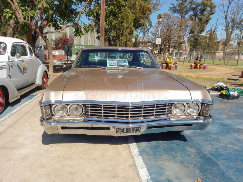 старый металлический бейдж 1967 chevrolet chevy caprice coupe двухдверный автомобиль в парке. стоковые фото