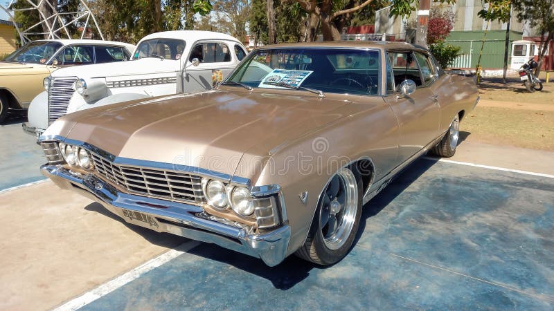 старый металлический бейдж 1967 chevrolet chevy caprice coupe двухдверный автомобиль в парке. стоковые фото