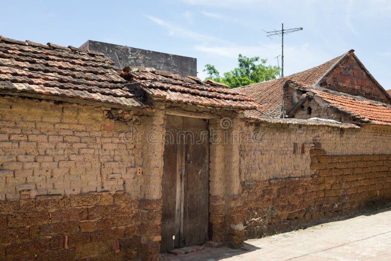 Старый постаретые вход и стена дома сделанные из laterite в деревне бегства Duong старой, районе Tay сына, Ханое, Вьетнаме стоковая фотография Старый постаретые вход и стена дома сделанные из laterite в деревне бегства Duong старой, районе Tay сына, Ханое, Вьетнаме стоковая фотография