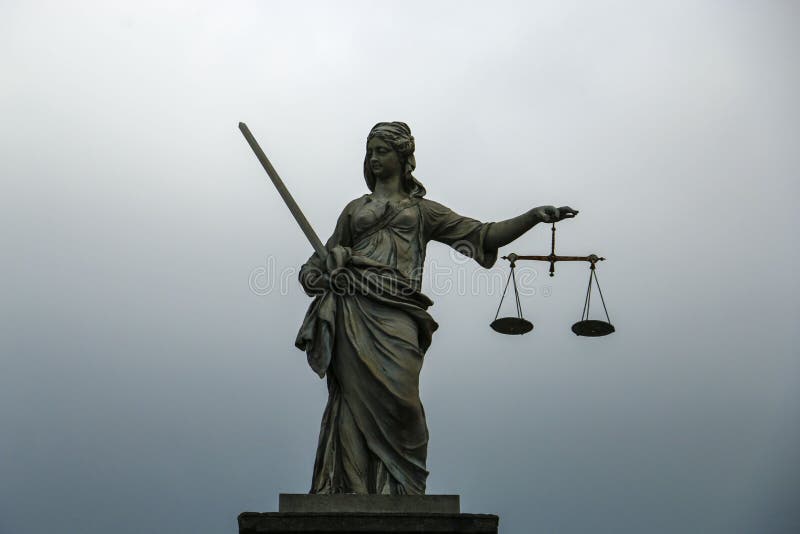 Статуя Themis, богиня правосудия на сер-голубой предпосылке стоковое изображение Статуя Themis, богиня правосудия на сер-голубой предпосылке стоковое изображение
