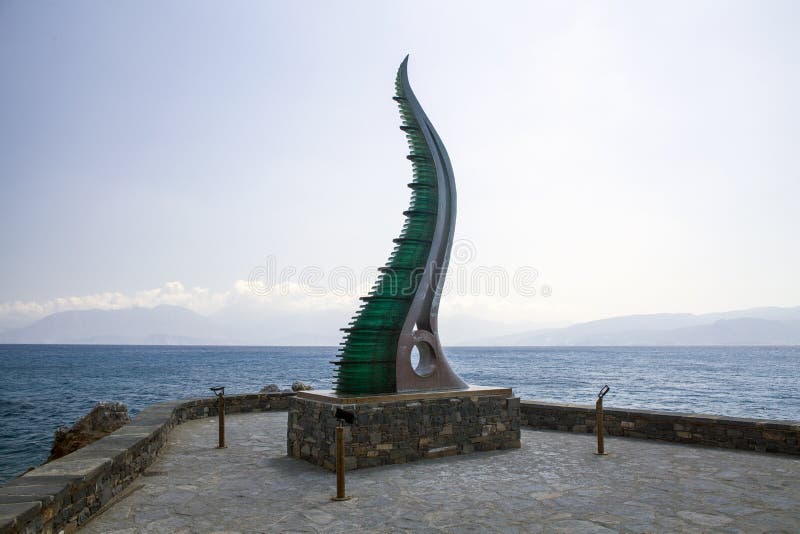 Статуя изобилия, рожок Amalthea на водах окаймляется, ажио Nikolaos, Крит стоковая фотография rf Статуя изобилия, рожок Amalthea на водах окаймляется, ажио Nikolaos, Крит стоковая фотография rf