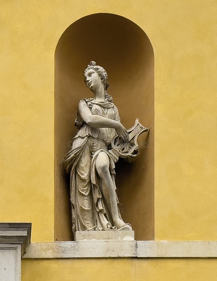 Pictured is a statue of the Muse of Dance, Terpsichore, with her lyre on the exterior of the Teatro Communale Alighieri, an opera house located at 2 Via Miriani in Ravenna, Italy. The theatre was designed by Venetian architects, Tommaso Meduna and his brother Giambattista and was inaugurated on the 15th of May 1852. It was named for the famous poet, Dante Aligheri who spent the last four years of his life in Ravenna. Reflecting the style of the Venetian brothers, the exterior of the Alighieri is neo-classical with a four ionic columns and a portico with statues of four Muses. Pictured is a statue of the Muse of Dance, Terpsichore, with her lyre on the exterior of the Teatro Communale Alighieri, an opera house located at 2 Via Miriani in Ravenna, Italy. The theatre was designed by Venetian architects, Tommaso Meduna and his brother Giambattista and was inaugurated on the 15th of May 1852. It was named for the famous poet, Dante Aligheri who spent the last four years of his life in Ravenna. Reflecting the style of the Venetian brothers, the exterior of the Alighieri is neo-classical with a four ionic columns and a portico with statues of four Muses.