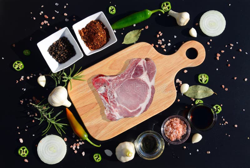 Стейк мяса на разделочной доске и перце, лист залива, розмариновом масле, луках, соли, оливковом масле, соевом соусе стоковое изображение Стейк мяса на разделочной доске и перце, лист залива, розмариновом масле, луках, соли, оливковом масле, соевом соусе стоковое изображение